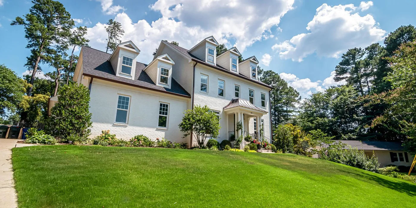 Two-storey family home with a wide green lawn — a typical residential service property